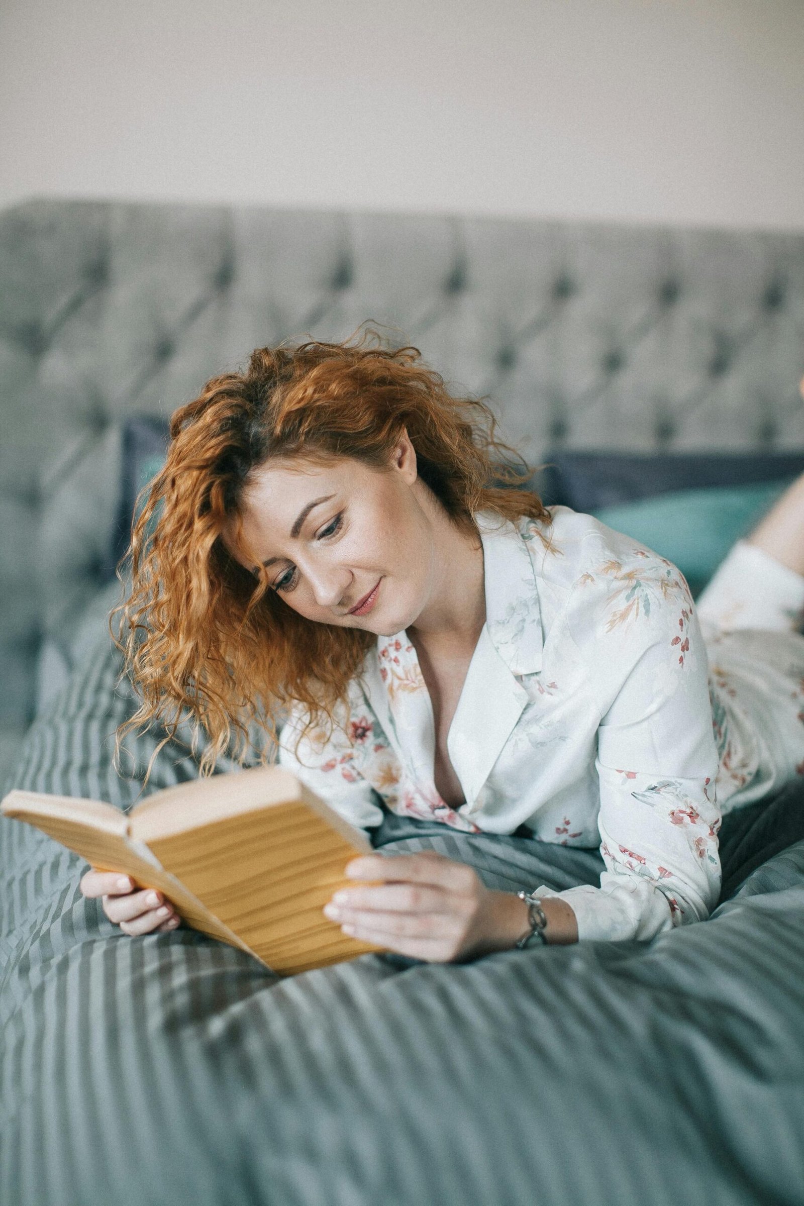 woman in bed reading erotica